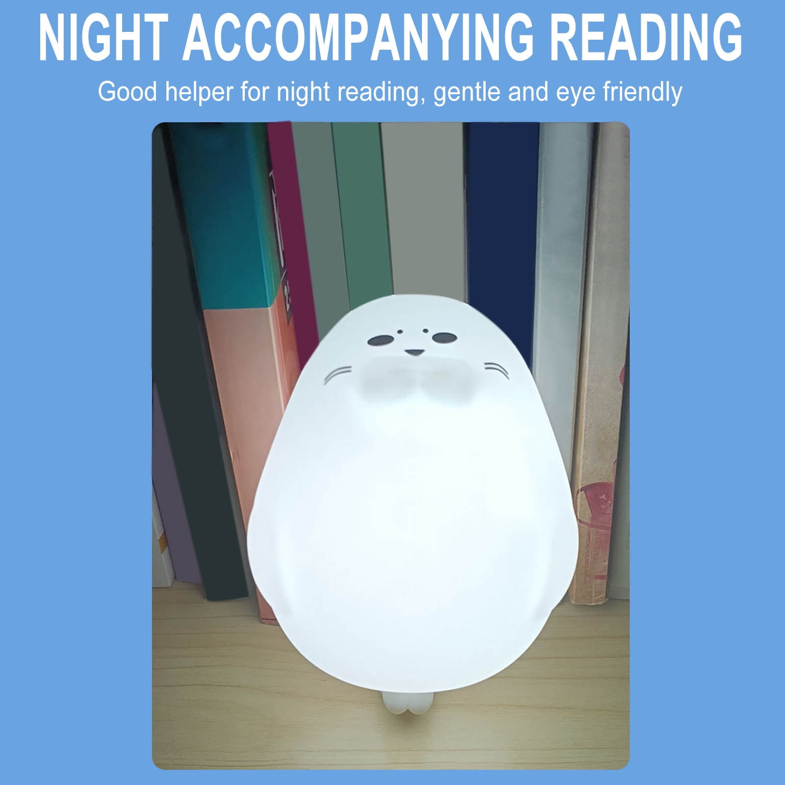 Eine weiße robbenförmige Nachtlampe steht auf einer Holzoberfläche vor bunten Büchern.