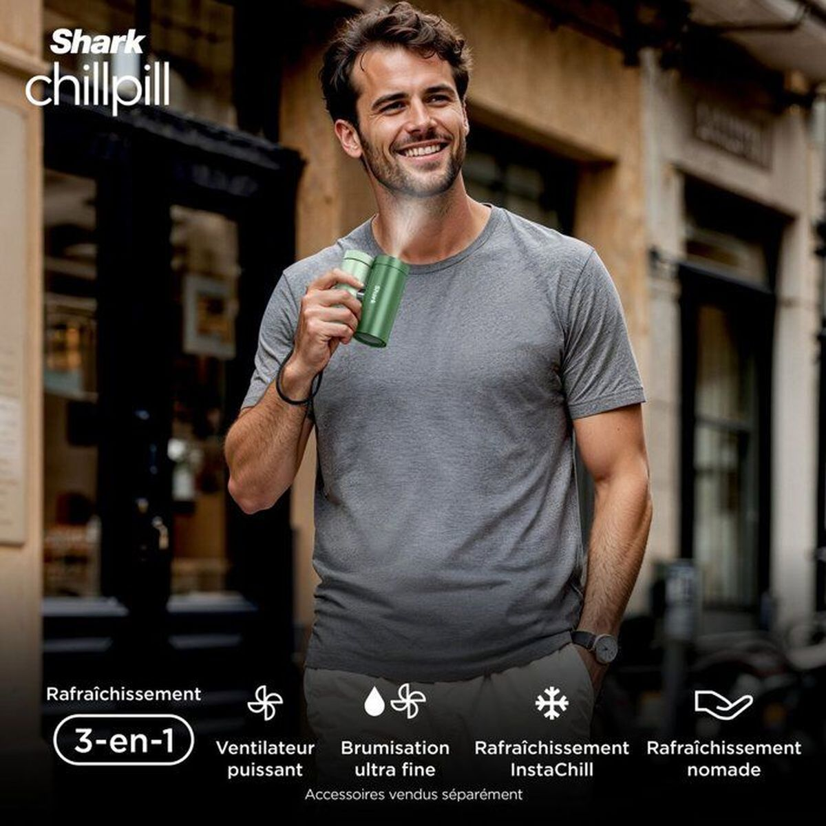 Un uomo sorridente tiene un ventilatore portatile verde e si spruzza acqua sul viso.