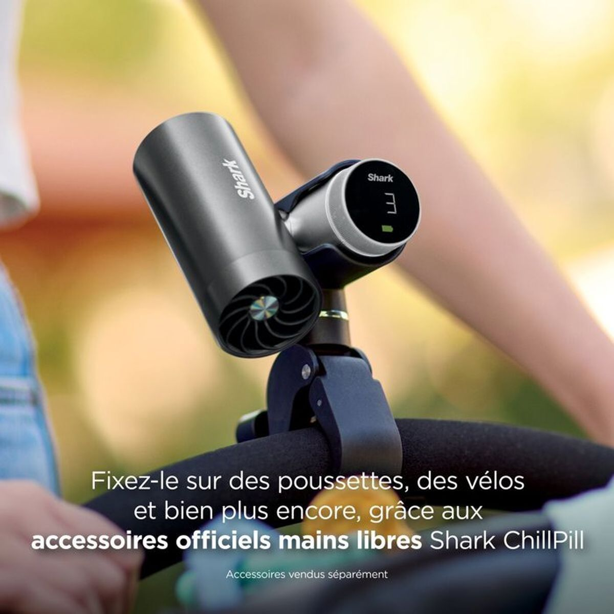Un ventilatore portatile Shark ChillPill grigio scuro attaccato al manubrio di un passeggino con testo in francese.