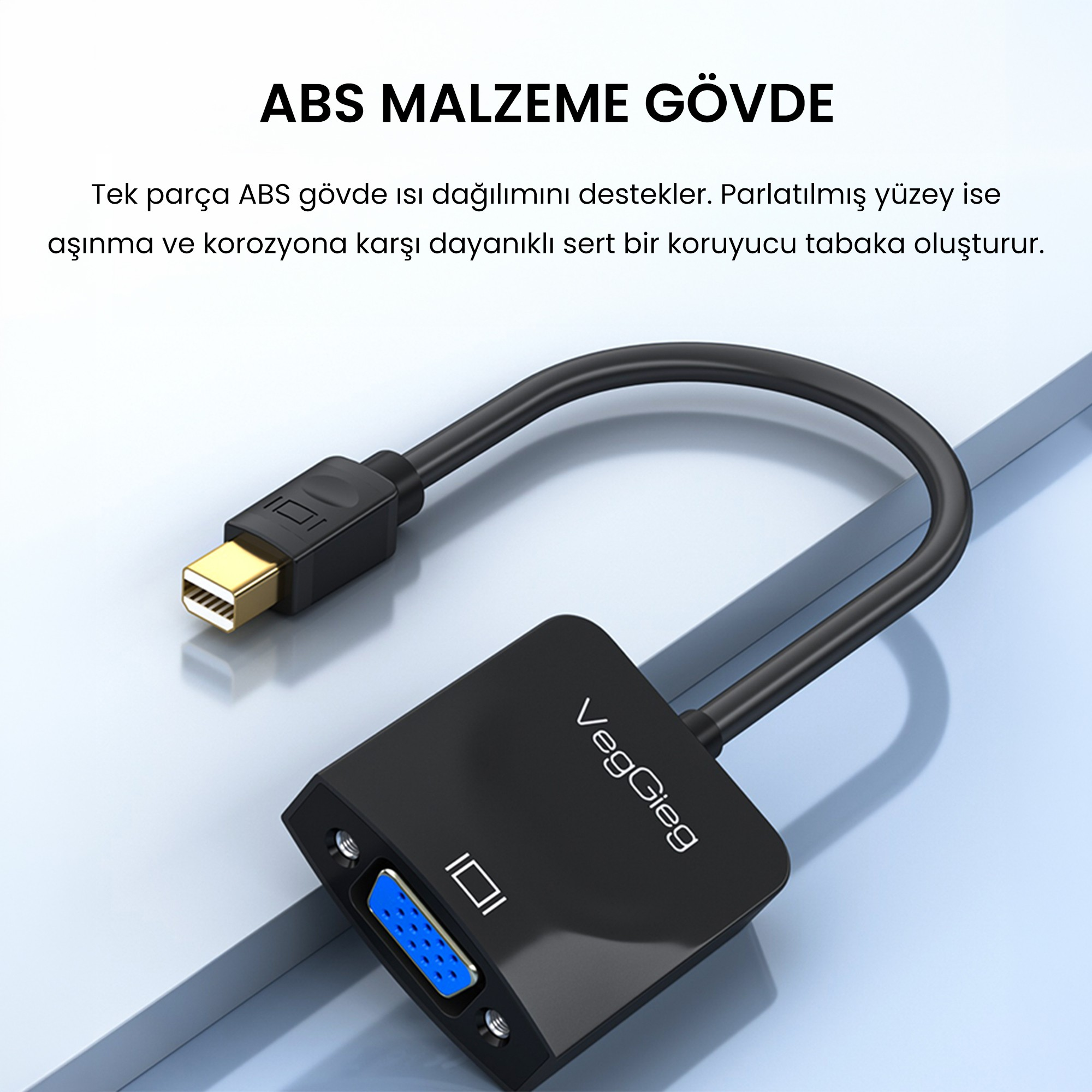 Açık renkli yüzey üzerinde kısa kablolu siyah renkli Mini DisplayPort - VGA dönüştürücü.