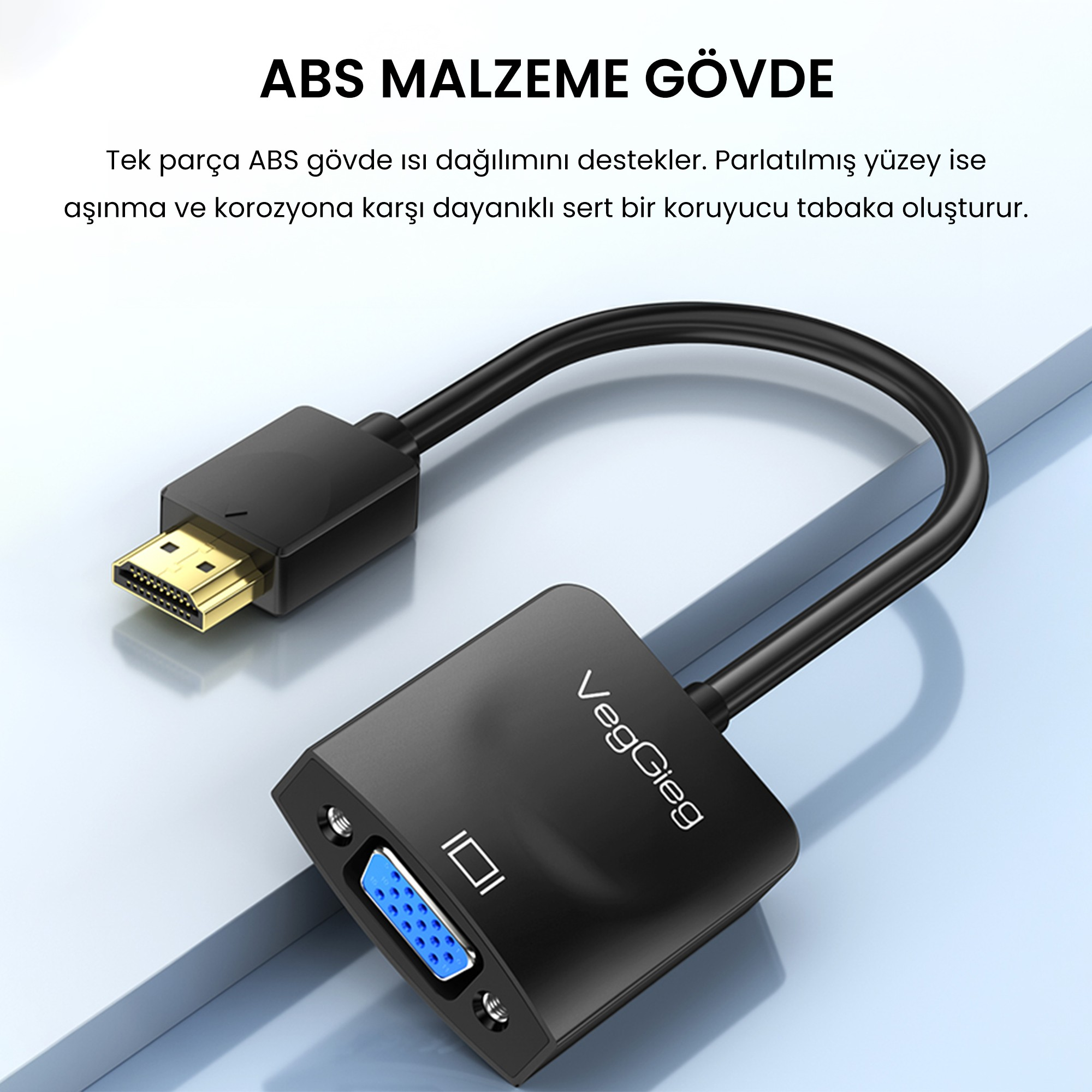 Açık mavi zemin üzerinde altın renkli HDMI konnektörüne sahip siyah VegGieg HDMI - VGA adaptörü.