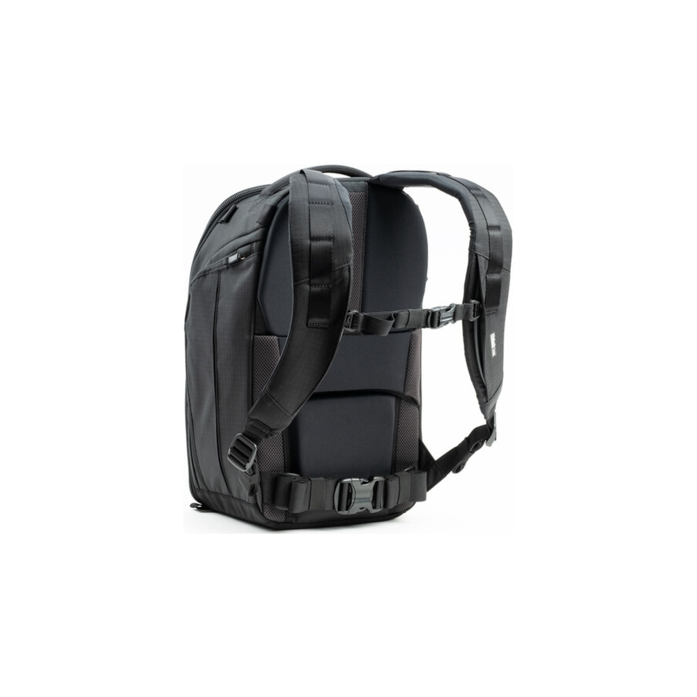 Una mochila fotográfica negra con correas acolchadas, correa para el pecho y cinturón sobre fondo blanco.