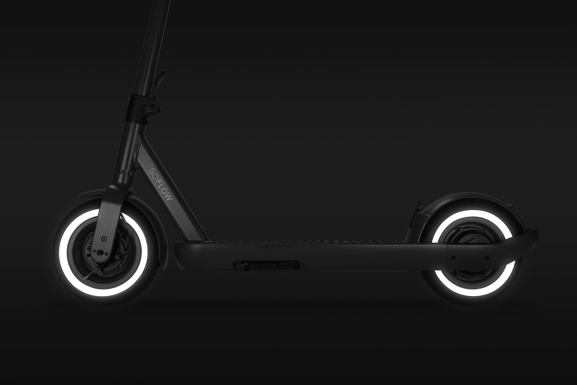 Ein schwarzer E-Scooter mit leuchtend weißen Ringen an den Reifen vor dunklem Hintergrund.