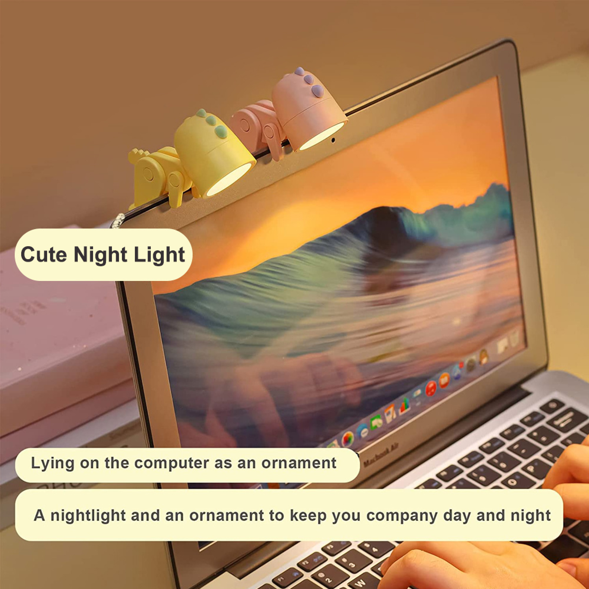 Zwei kleine dinosaurierförmige Lampen an einem Laptop-Bildschirm, die leuchten und hübsche Ornamente sind.