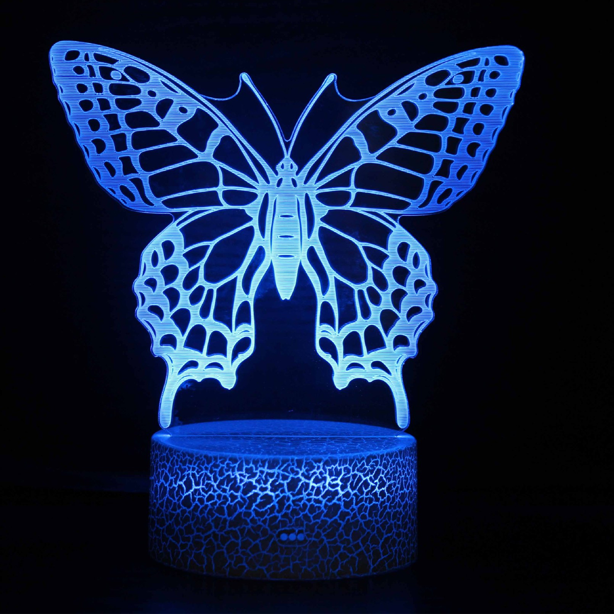 Eine blau leuchtende 3D-Schmetterlingslampe auf einem zylindrischen Sockel vor einem dunklen Hintergrund.