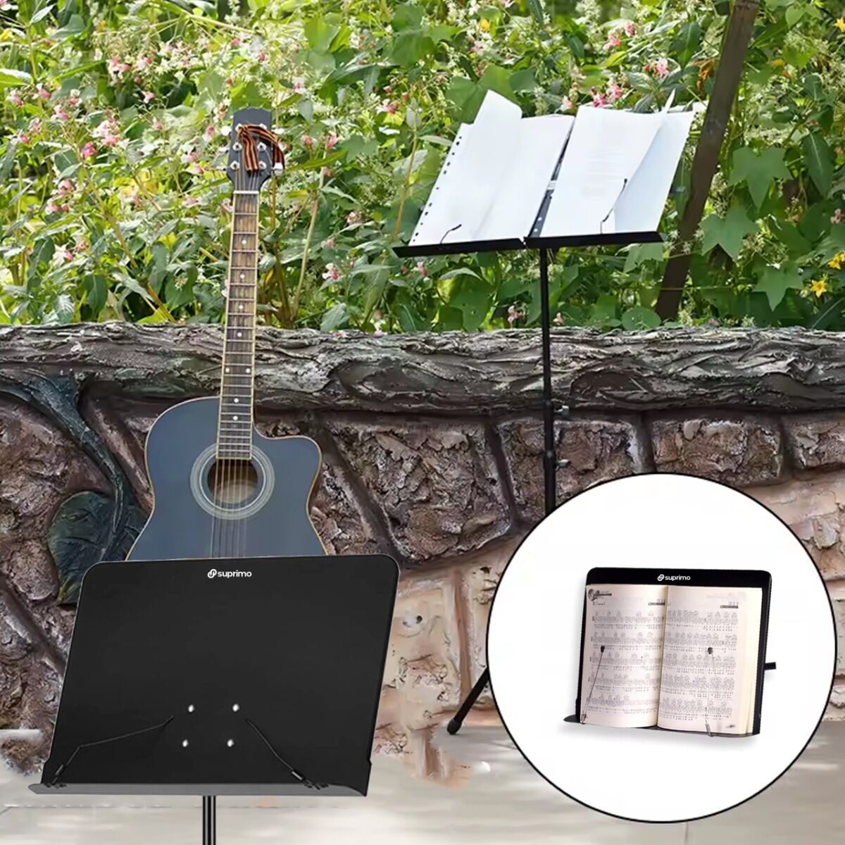 Eine Akustikgitarre steht vor einer Steinmauer neben zwei Notenständern mit Notenblättern im Freien.