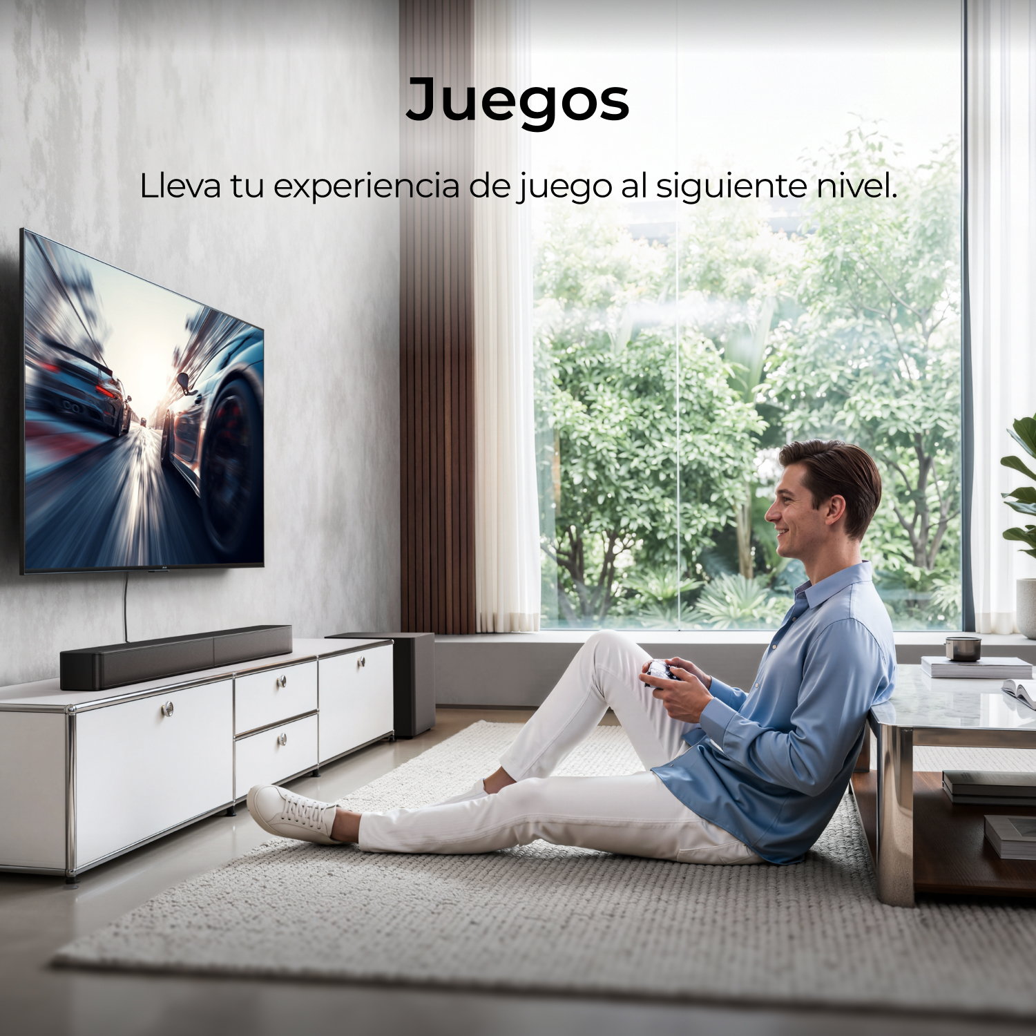 Un hombre sonriente sentado en la alfombra juega a videojuegos frente a un gran televisor.