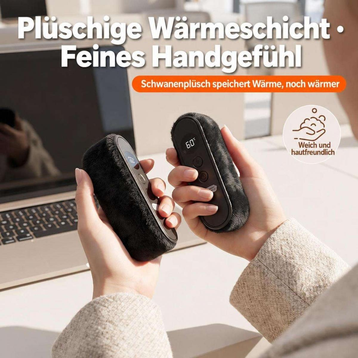 Eine Person hält zwei schwarze, flauschige Handwärmer mit digitaler Anzeige in den Händen, mit einem Laptop im Hintergrund.