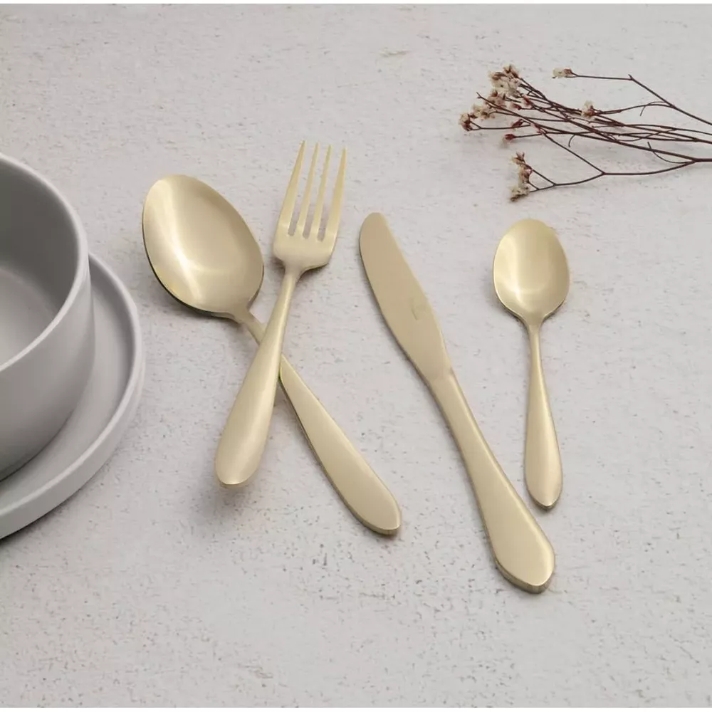 Couverts dorés avec cuillère, fourchette, couteau et petite cuillère près d'un bol gris.
