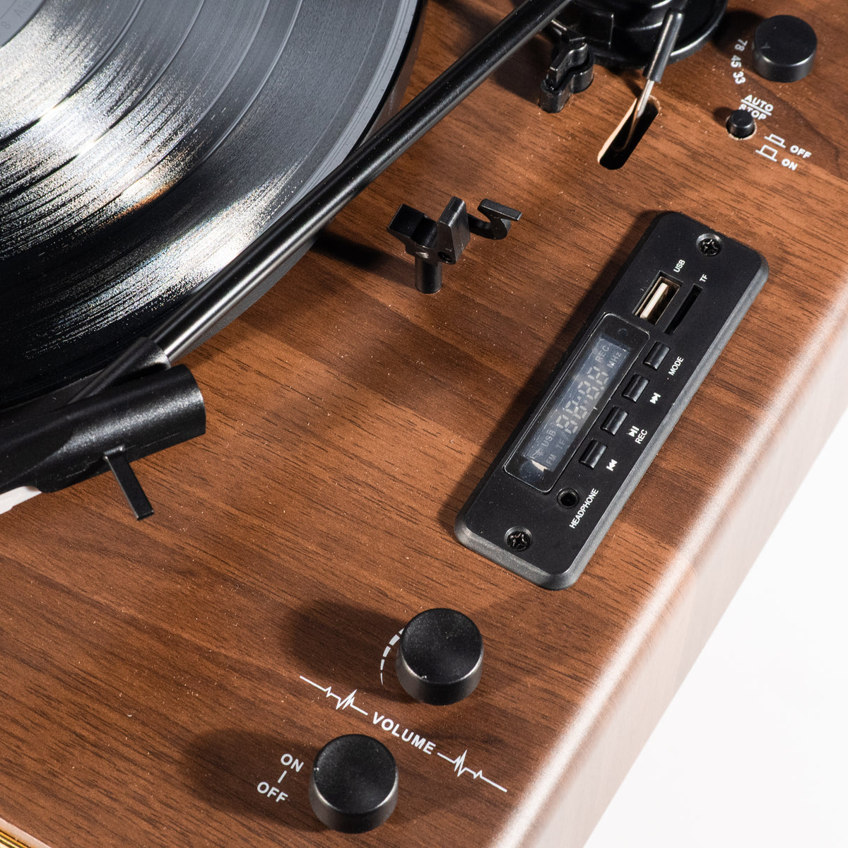 Ein Plattenspieler aus Holz mit schwarzem Vinyl, Bedienknöpfen und einem digitalen Display.