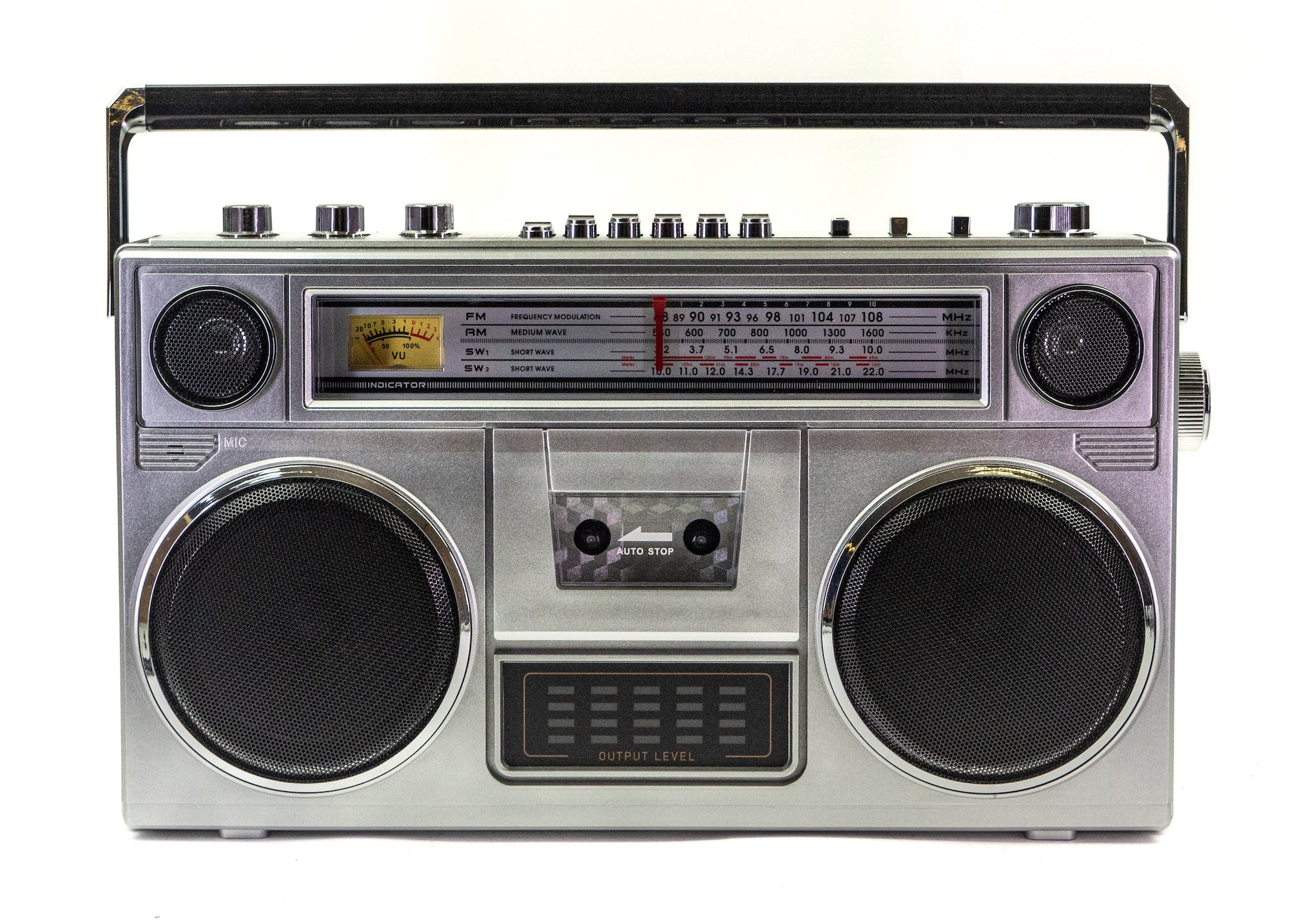 Ein silberner Retro-Ghettoblaster mit zwei großen Lautsprechern, Kassettendeck und analoger Skala auf weißem Grund.