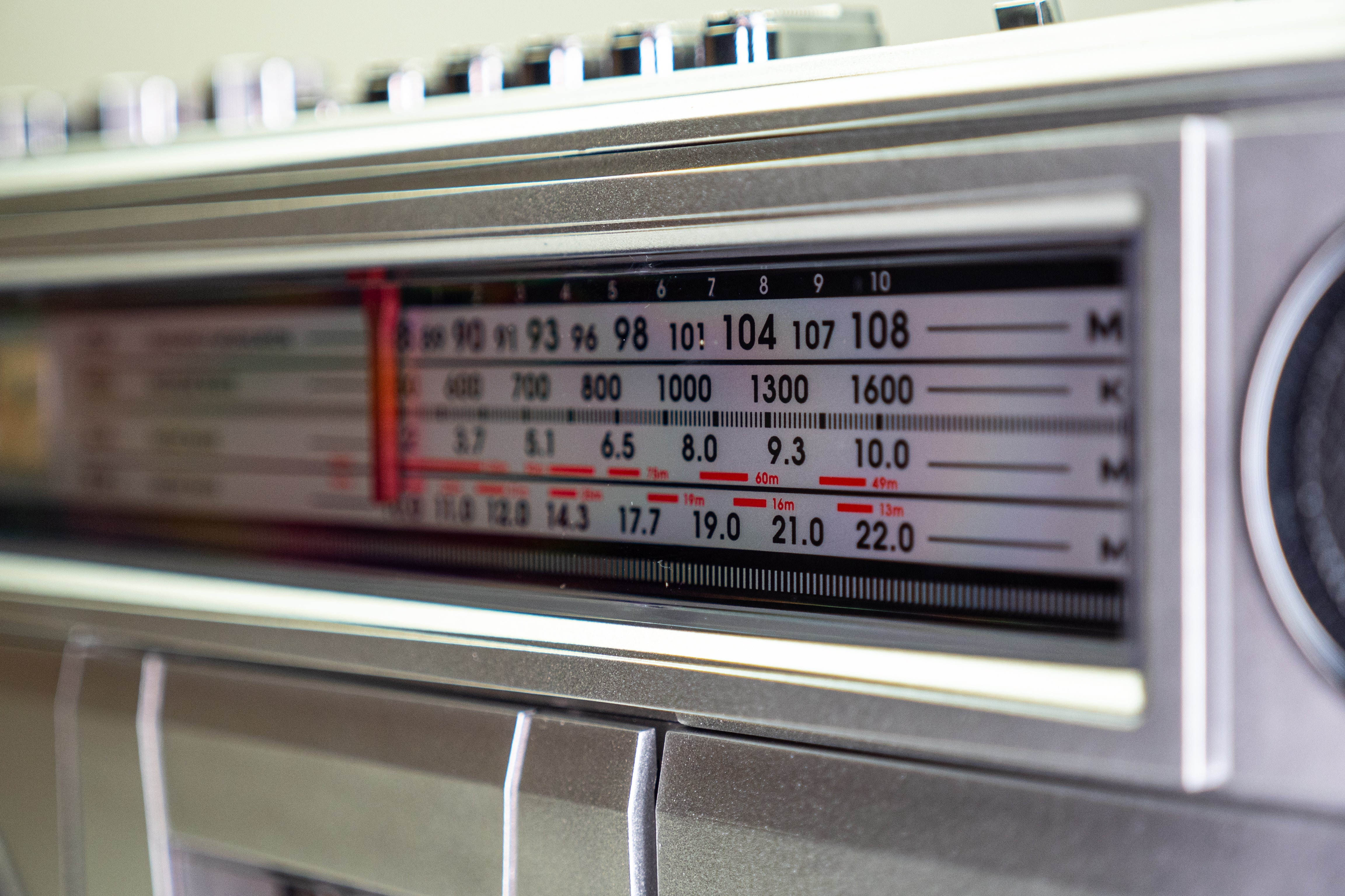Nahaufnahme des analogen Radiosenders mit roter Skalennadel.