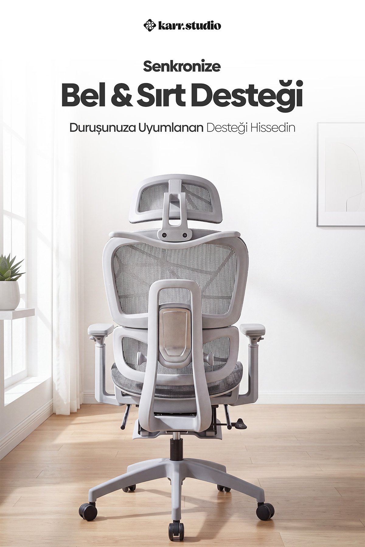 Aydınlık bir odada arkadan görünen gri ergonomik ofis koltuğu.
