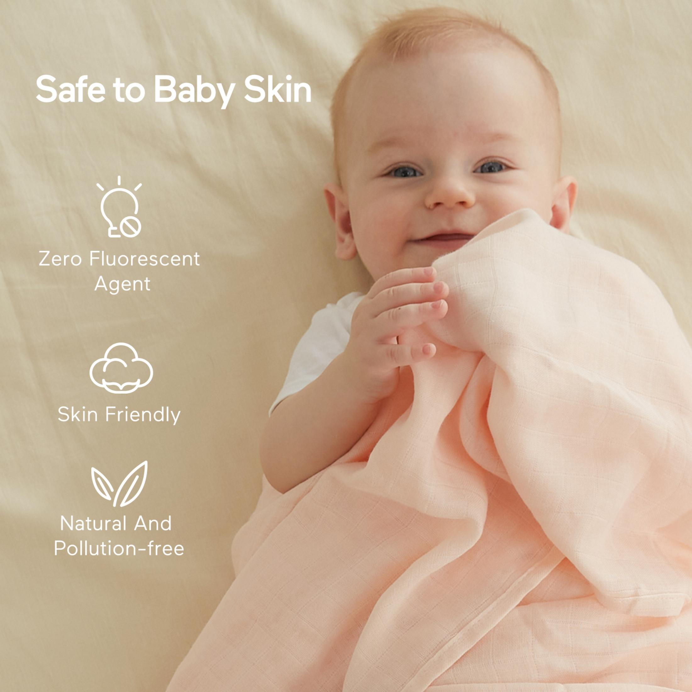 Un felice bambino sdraiato su una coperta tiene un panno rosa. Testo e icone evidenziano caratteristiche delicate sulla pelle.