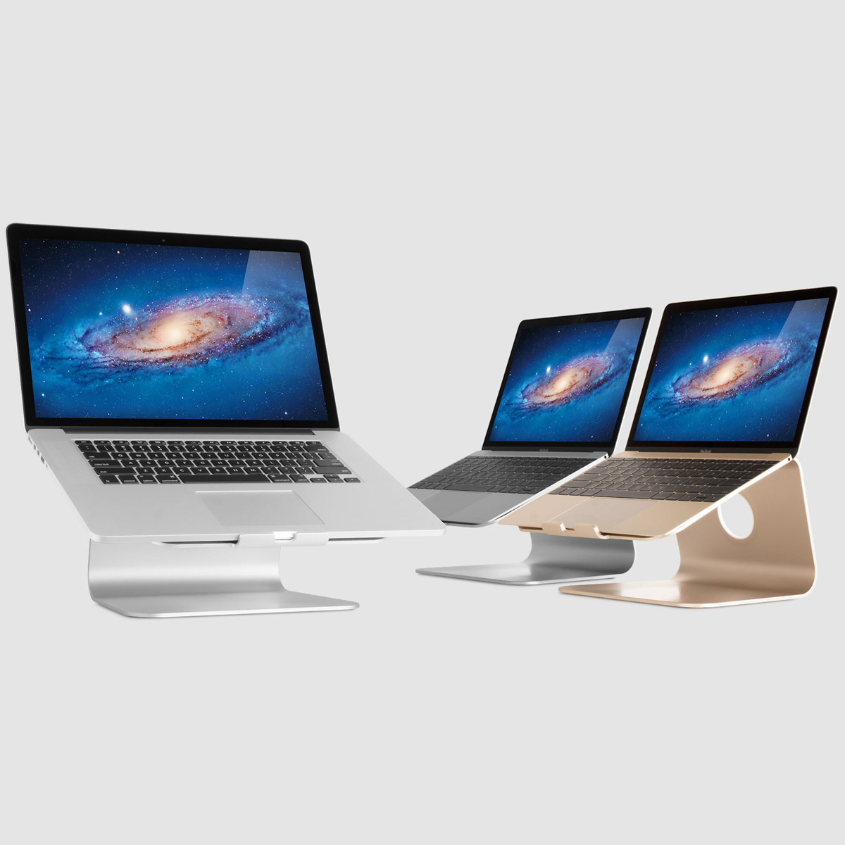 Drei Laptops in verschiedenen Farben auf eleganten Metallständern vor neutralem Hintergrund.