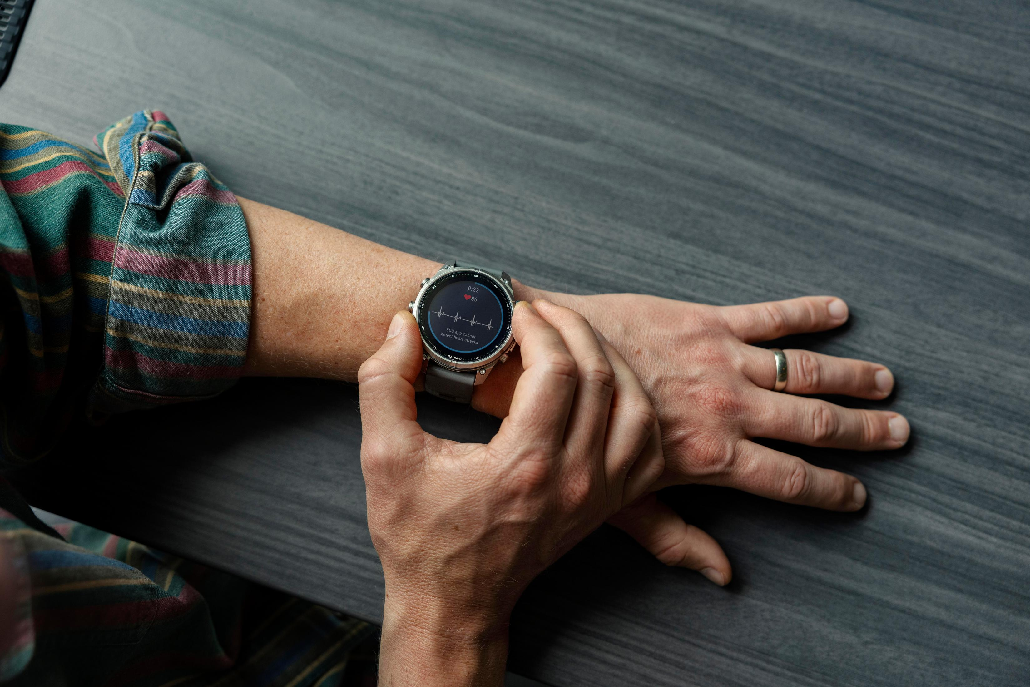 Persona che utilizza uno smartwatch al polso che mostra un ECG.