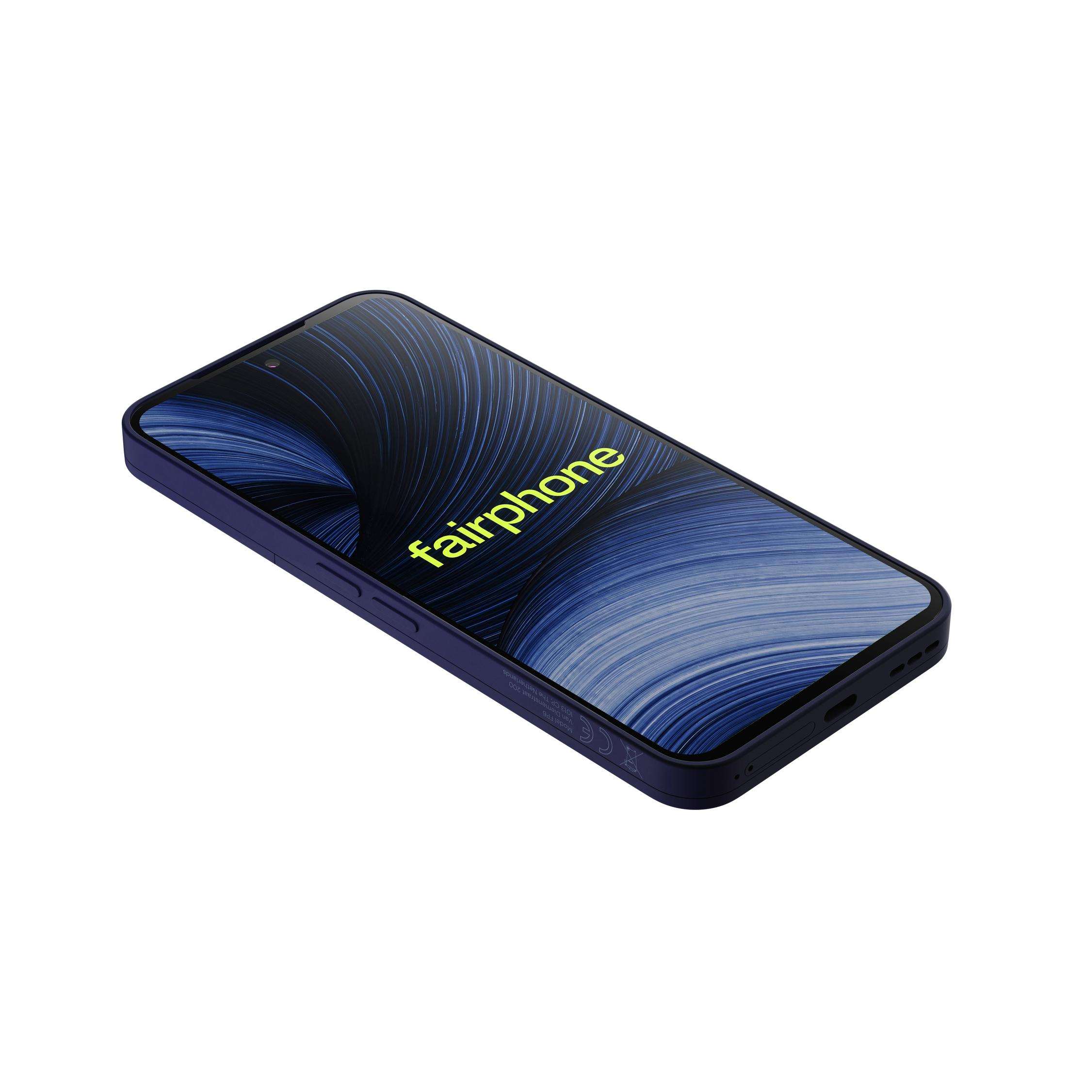 Uno smartphone Fairphone scuro con sfondo blu inclinato su superficie bianca.