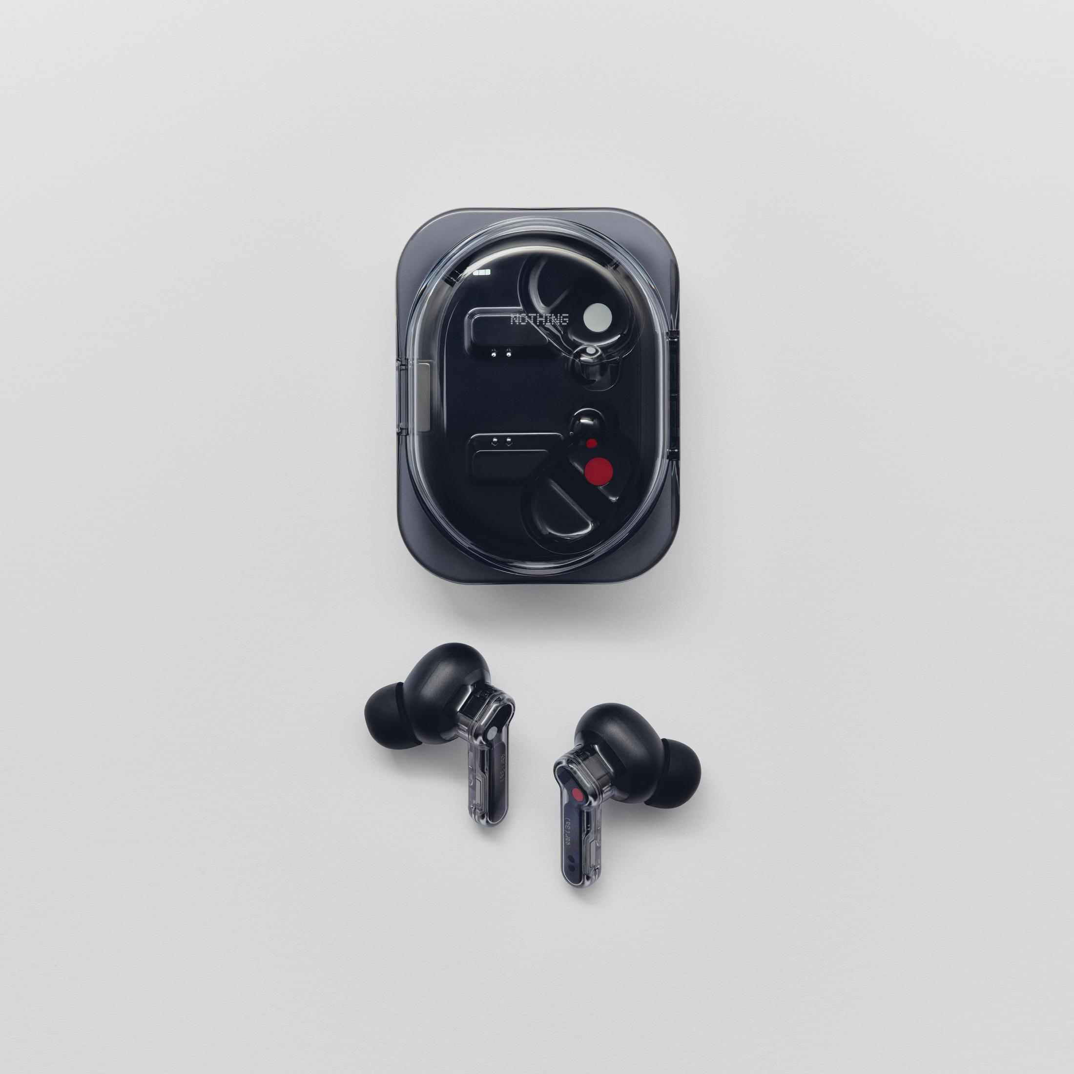 Auriculares inalámbricos negros con estuche de carga sobre fondo claro.