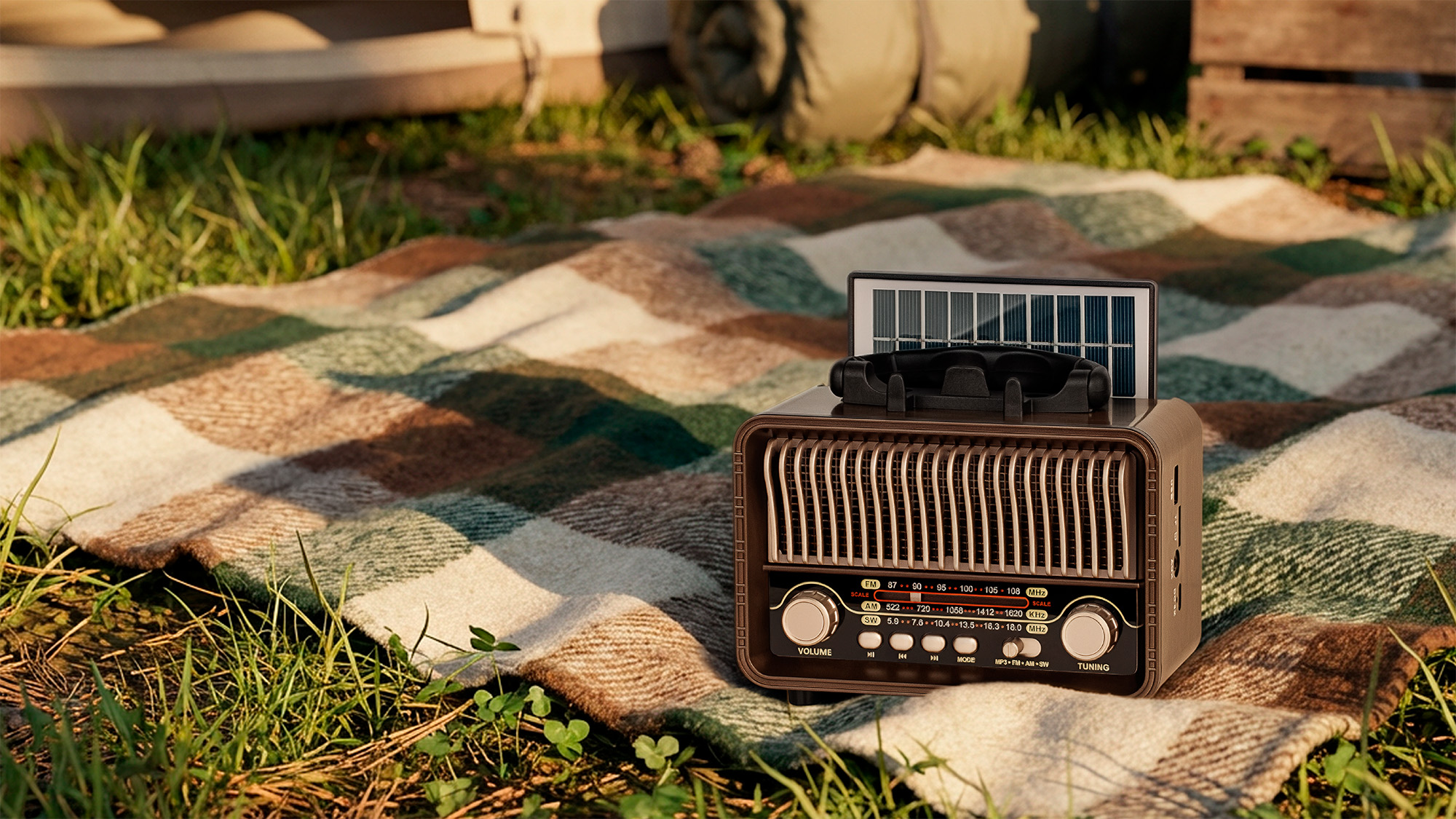 Radio w stylu retro z panelem słonecznym leży na w kratkę kocu na trawie.