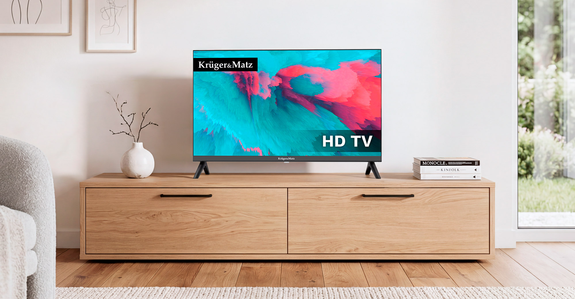 Telewizor z płaskim ekranem wyświetlający kolorową sztukę abstrakcyjną stoi na drewnianej szafce RTV w jasnym pokoju.