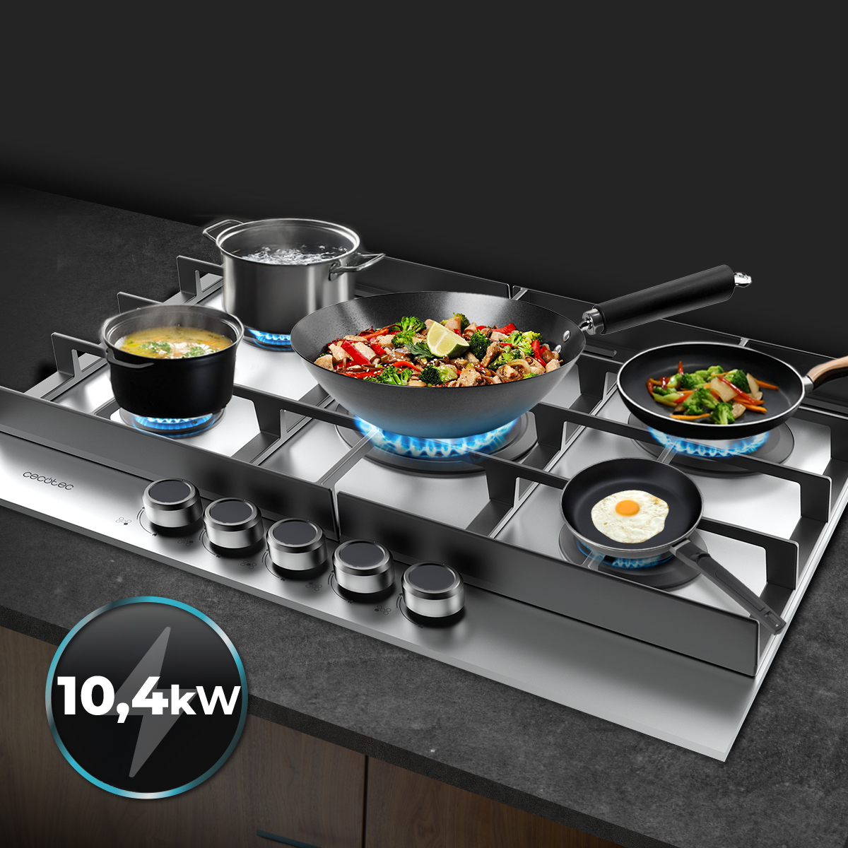 Una placa de gas de acero inoxidable con cinco llamas activas, con ollas y sartenes con comida cocinándose.