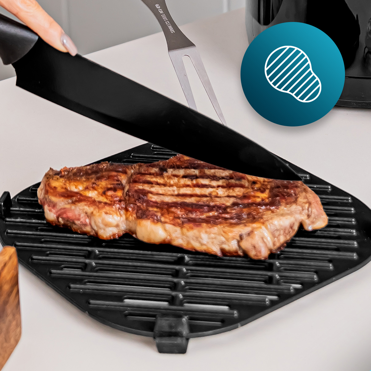 Una bistecca grigliata su una padella nera scanalata, tagliata con un coltello.