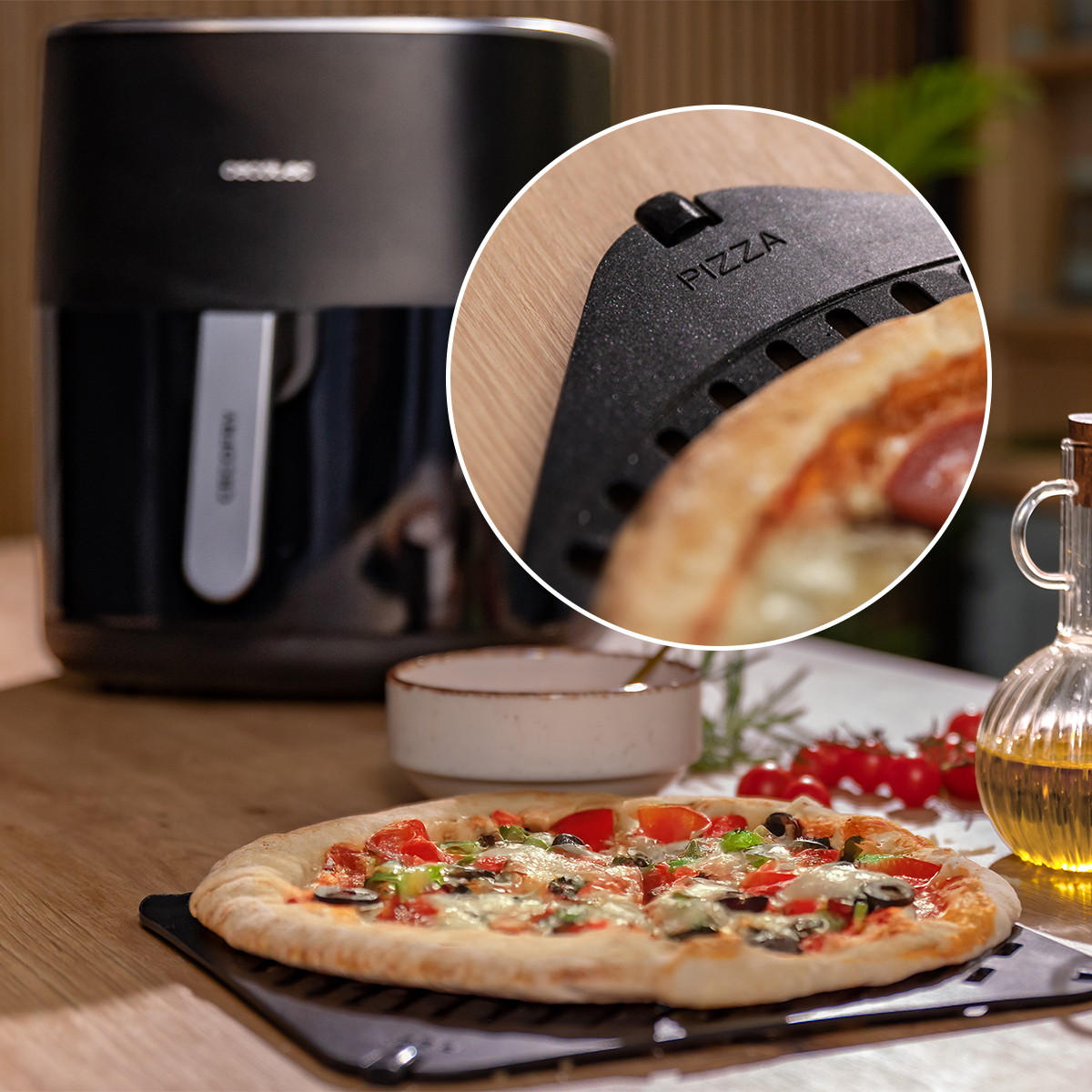 Pizza na czarnej podstawce z przybliżeniem w kółku, w tle frytkownica beztłuszczowa.