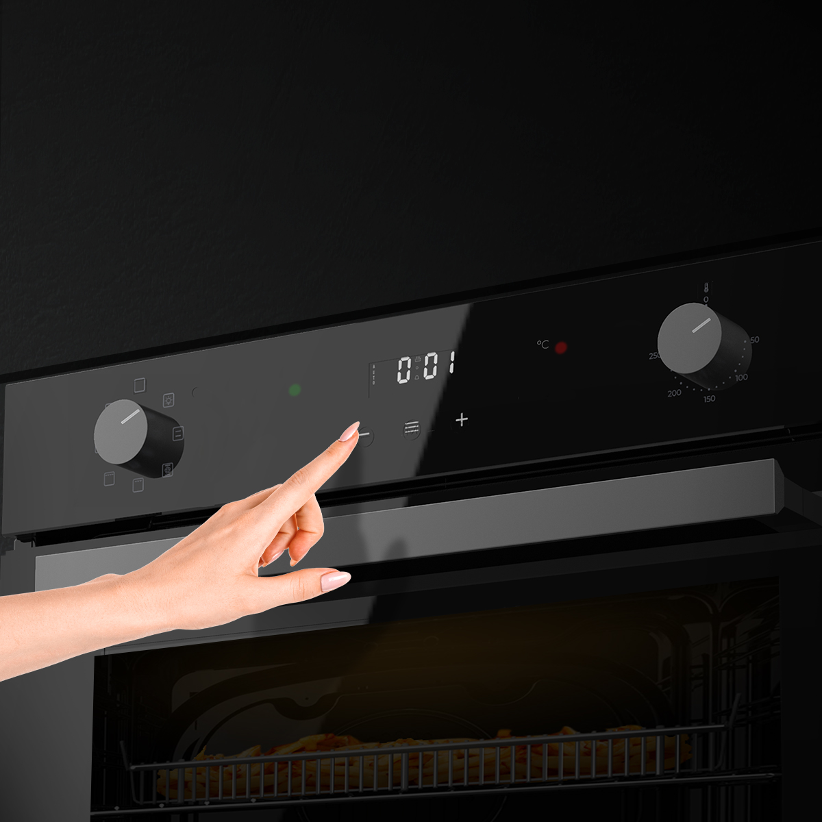 Una mano toca los controles de un horno negro moderno con pantalla digital y perillas giratorias.