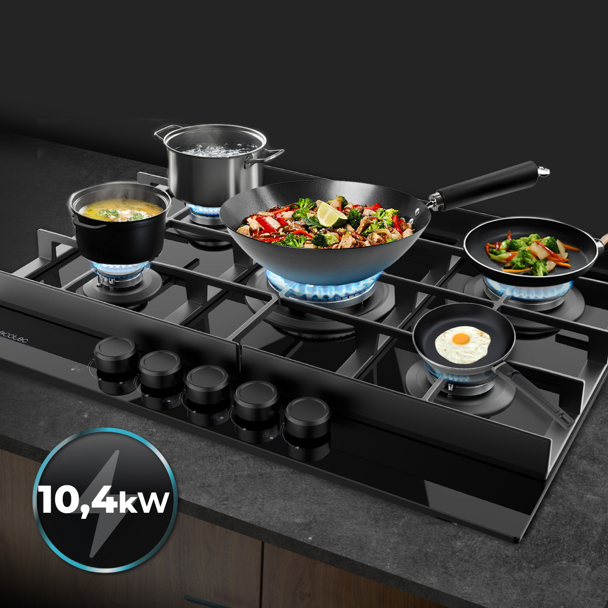 Una placa de gas negra con ollas, sartenes y un wok cocinando varios platos sobre llamas azules, etiquetada como 10,4kW.