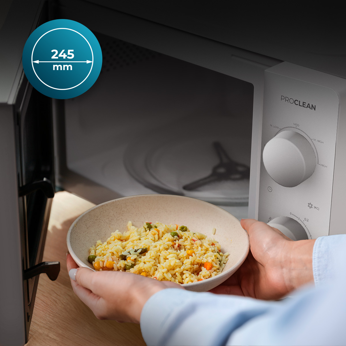 Persona coloca un bol de arroz frito y verduras en un microondas blanco.