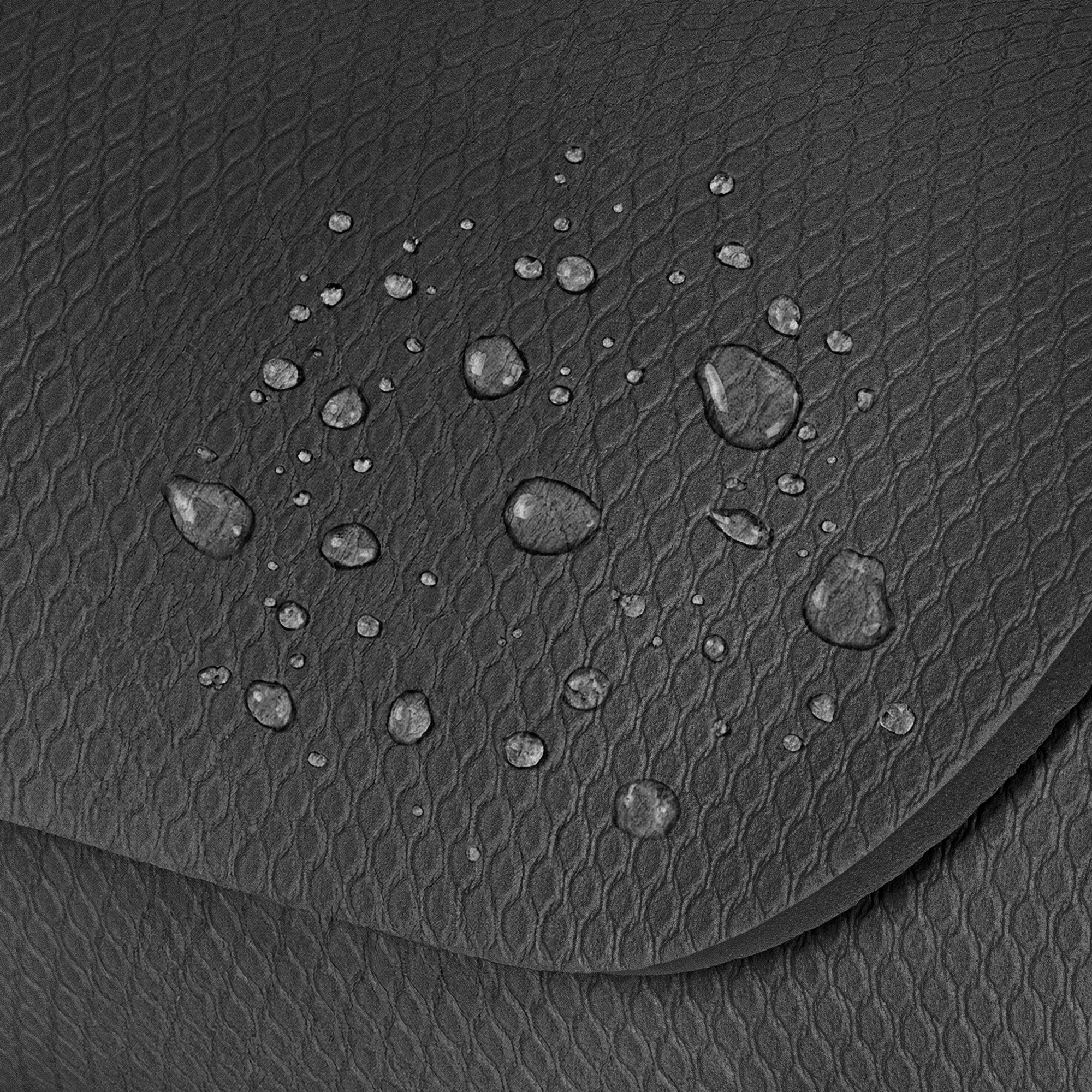 Krople wody na teksturowanej czarnej powierzchni.