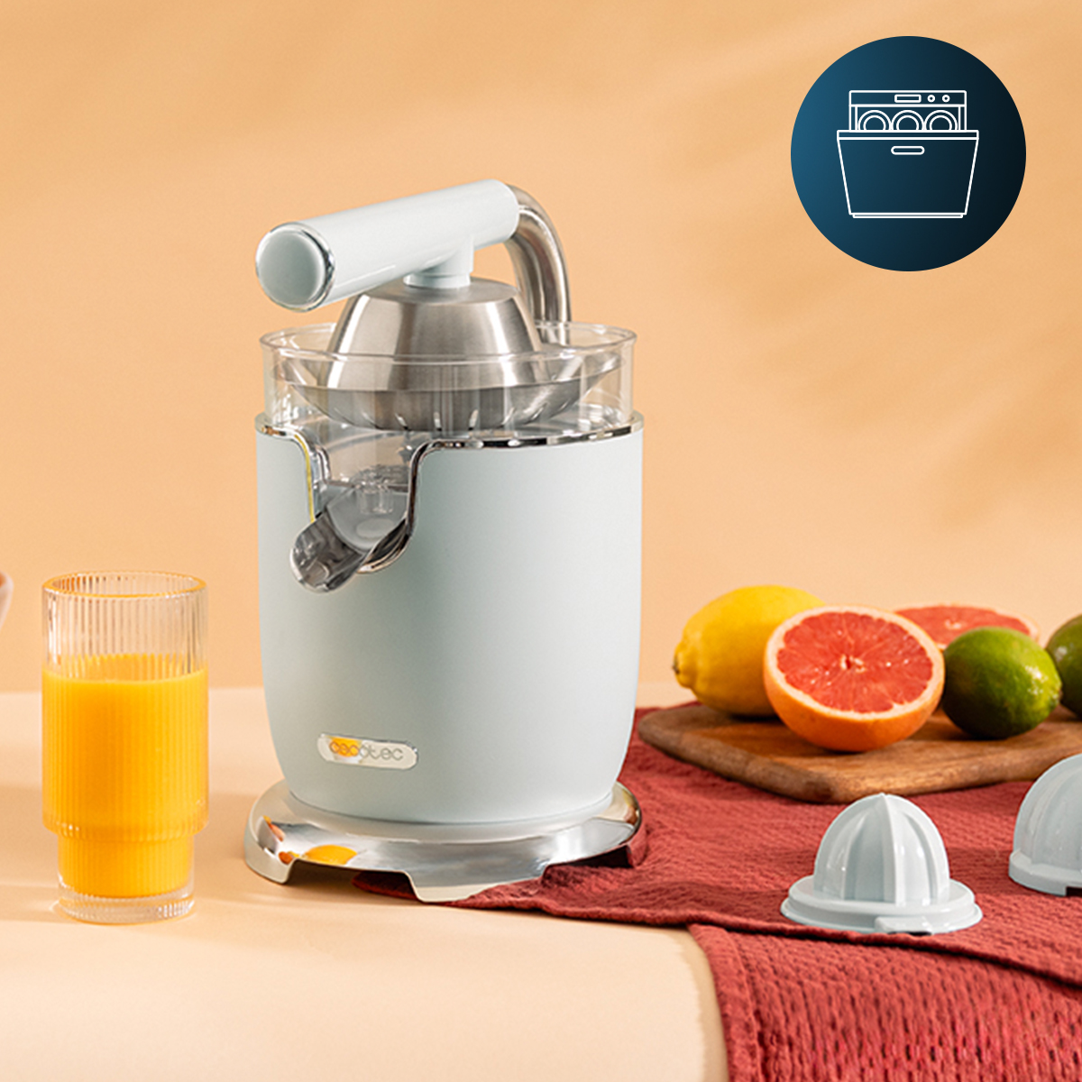 Spremiagrumi elettrico azzurro con bicchiere di succo e frutta su sfondo beige.