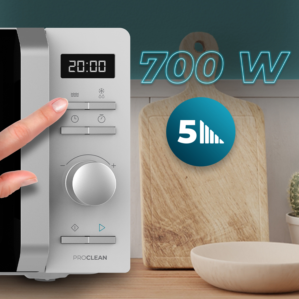Un dedo presiona el panel de control de un microondas plateado de 700 W.