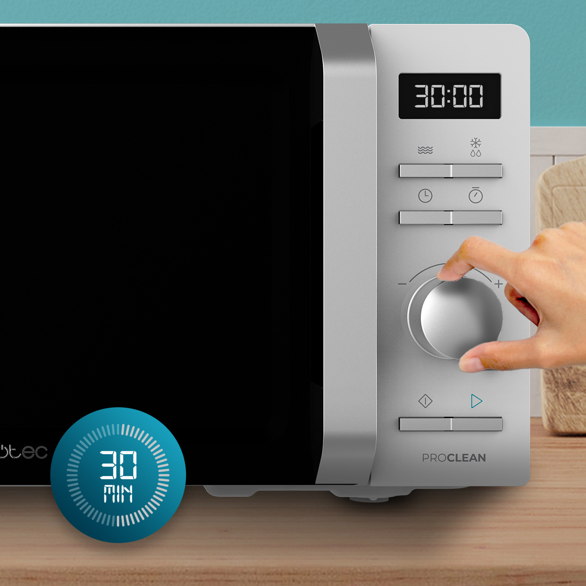 Una mano gira la perilla plateada en un microondas moderno con pantalla digital.