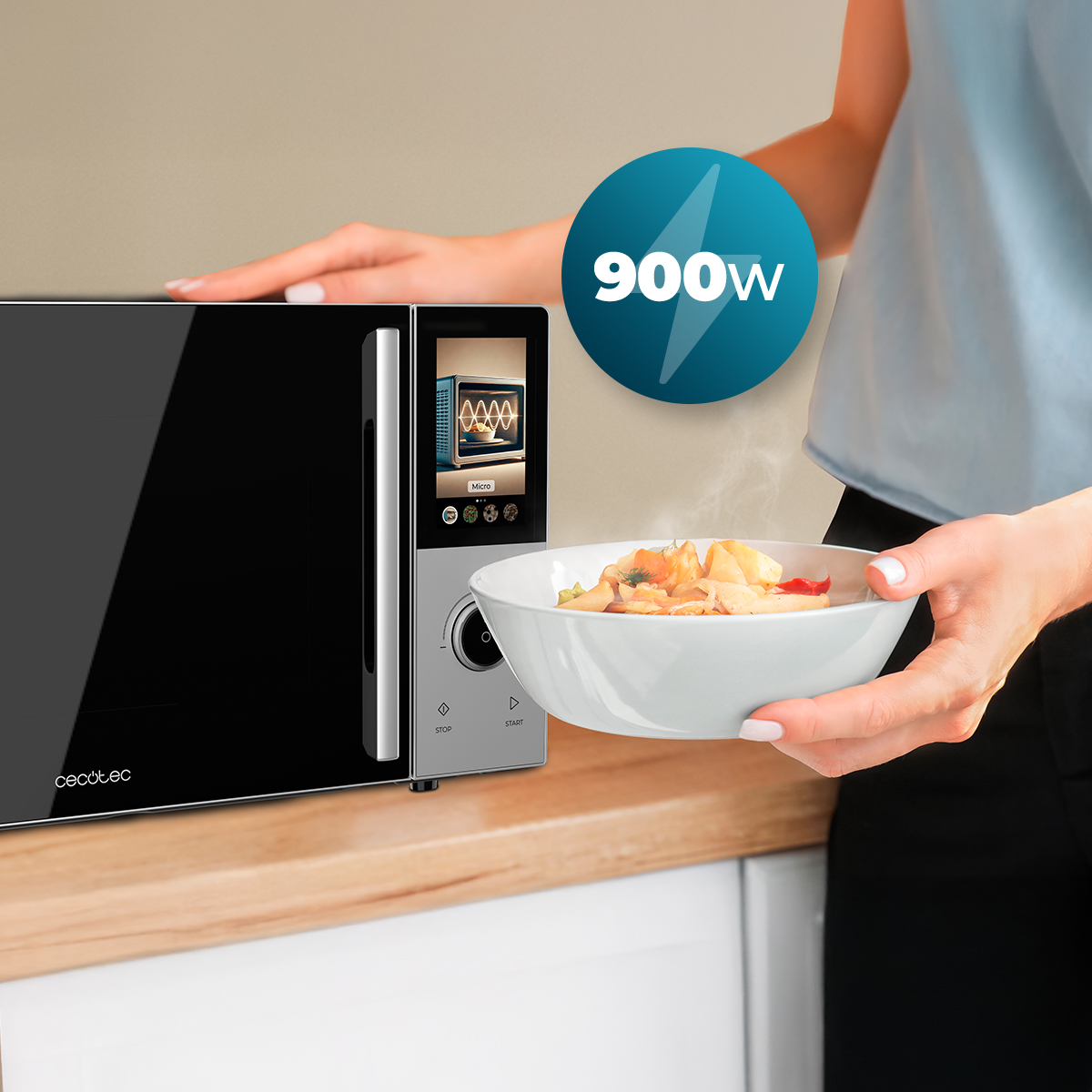 Una mujer sostiene un plato de comida caliente frente a un microondas Cecotec de 900W.