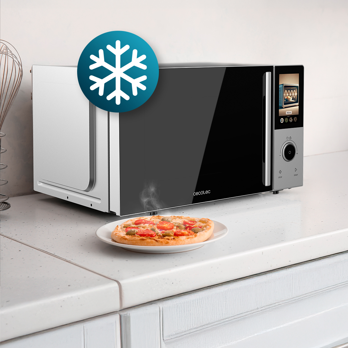 Un microondas moderno sobre una encimera blanca con un plato de pizza caliente delante y un icono de copo de nieve.