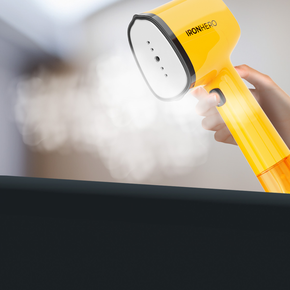 Una mano sostiene un vaporizador de ropa amarillo brillante que emite vapor sobre un fondo difuminado.