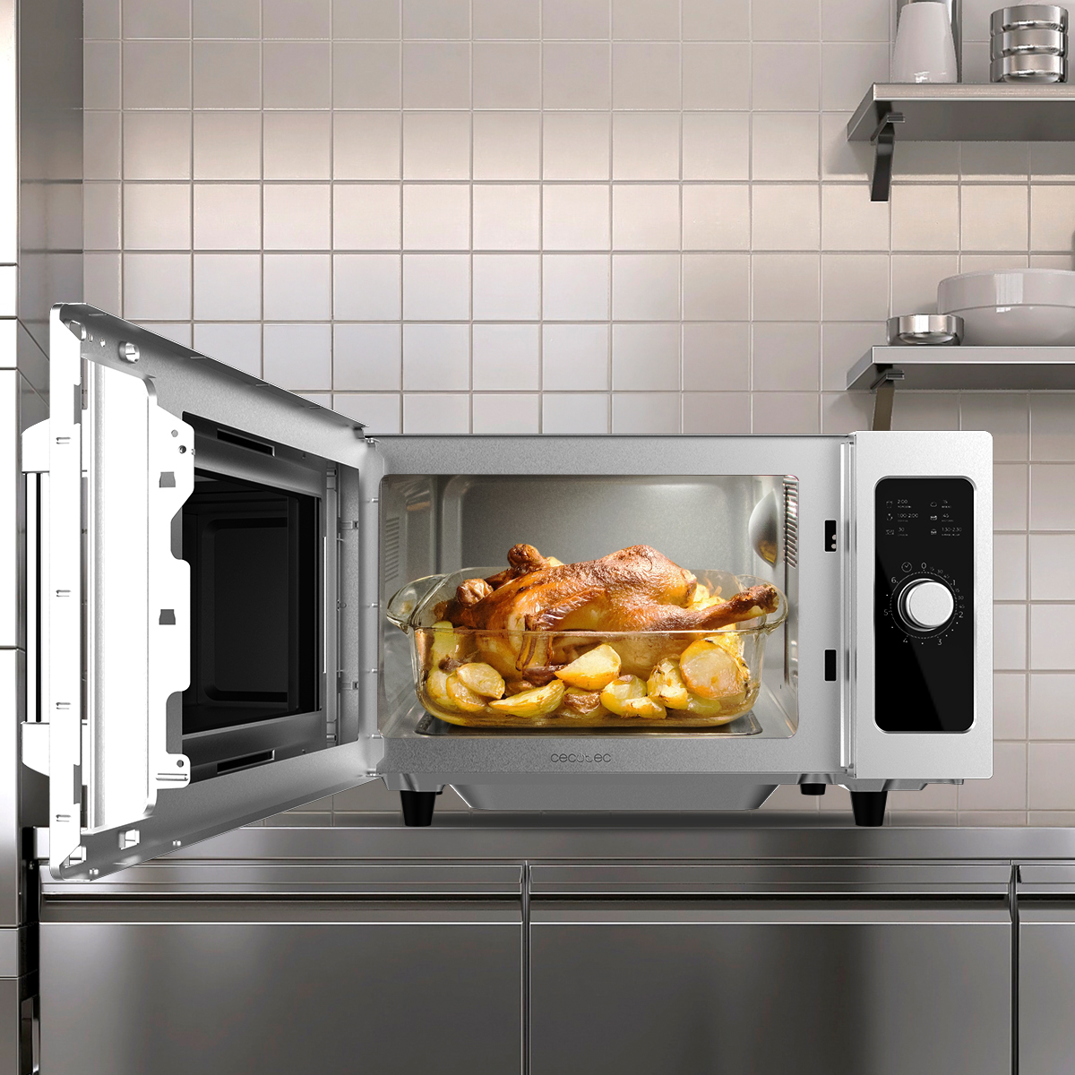 Un horno abierto en un mostrador de acero inoxidable muestra un pollo asado con patatas en una fuente de vidrio.