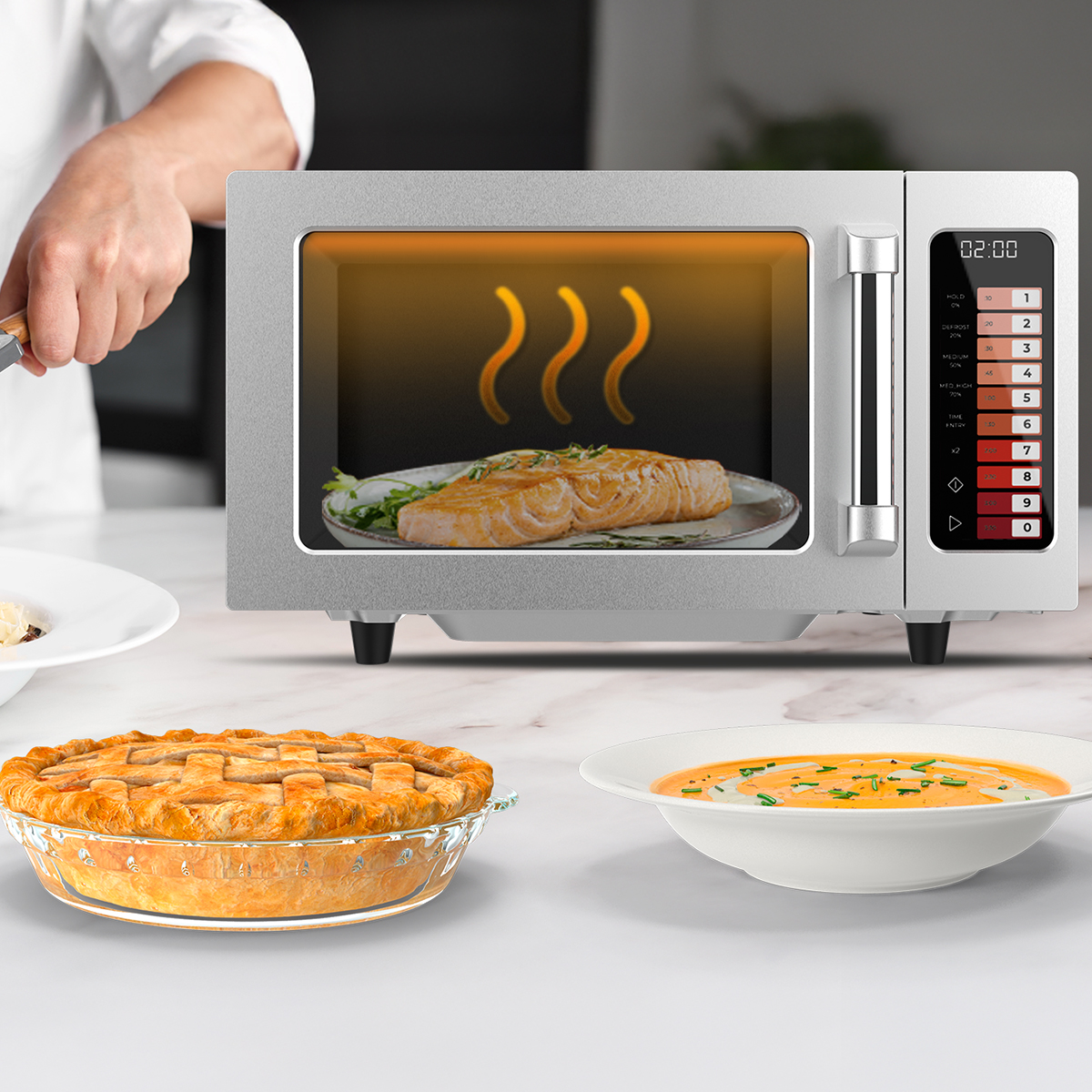 Un microondas plateado con un pastel y sopa en primer plano y comida visible adentro.