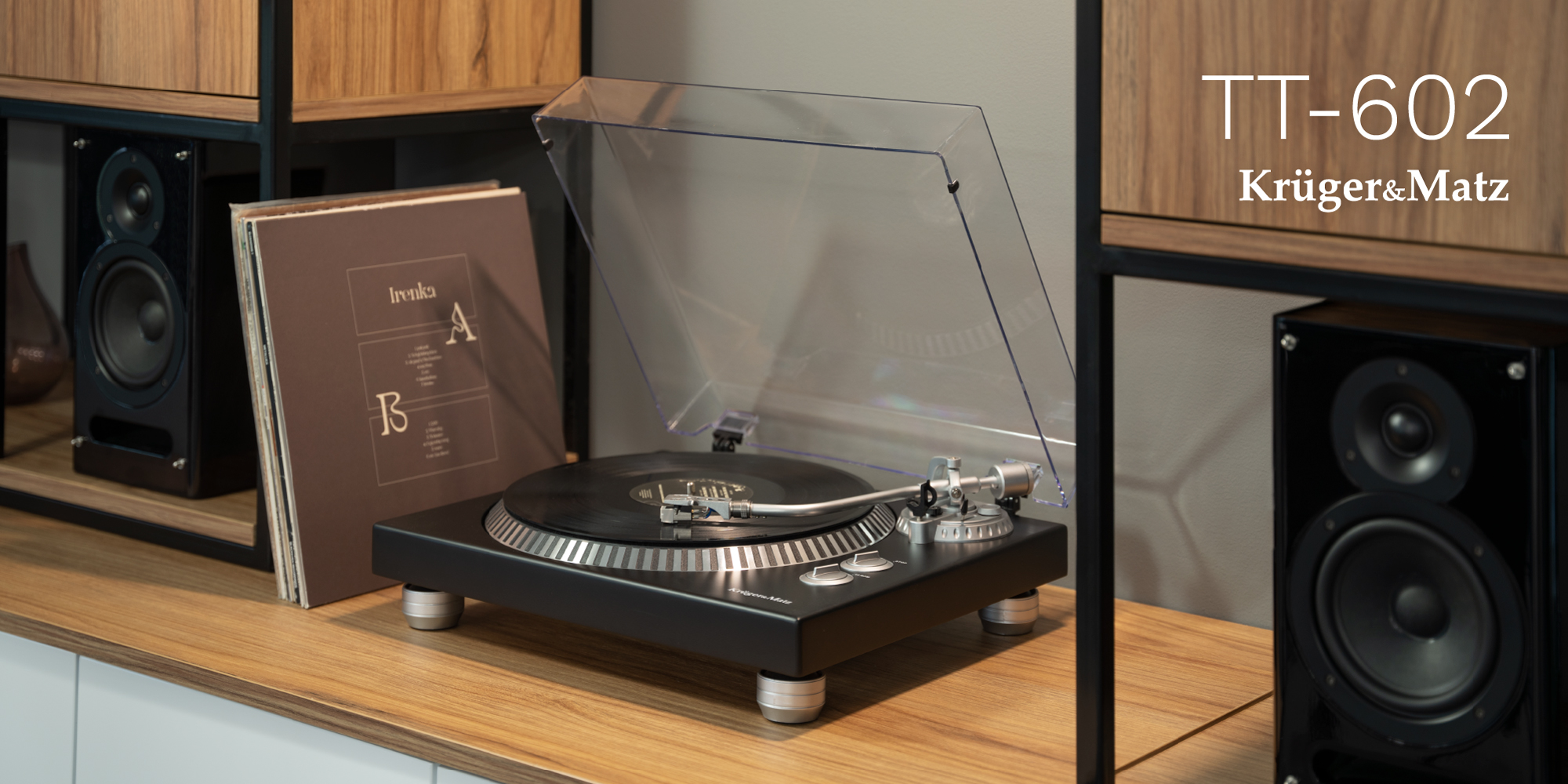 Czarny gramofon Krüger&Matz TT-602 z otwartą przezroczystą pokrywą, płytą winylową i głośnikami.
