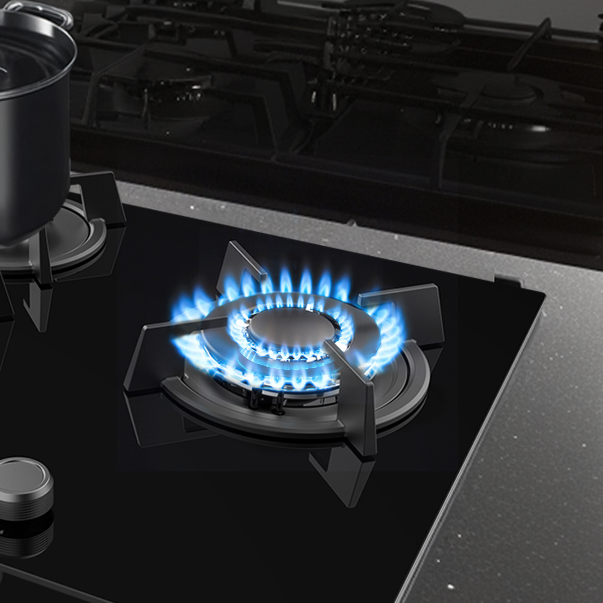 Una placa de gas negra con una llama azul encendida en un quemador y una olla al lado.