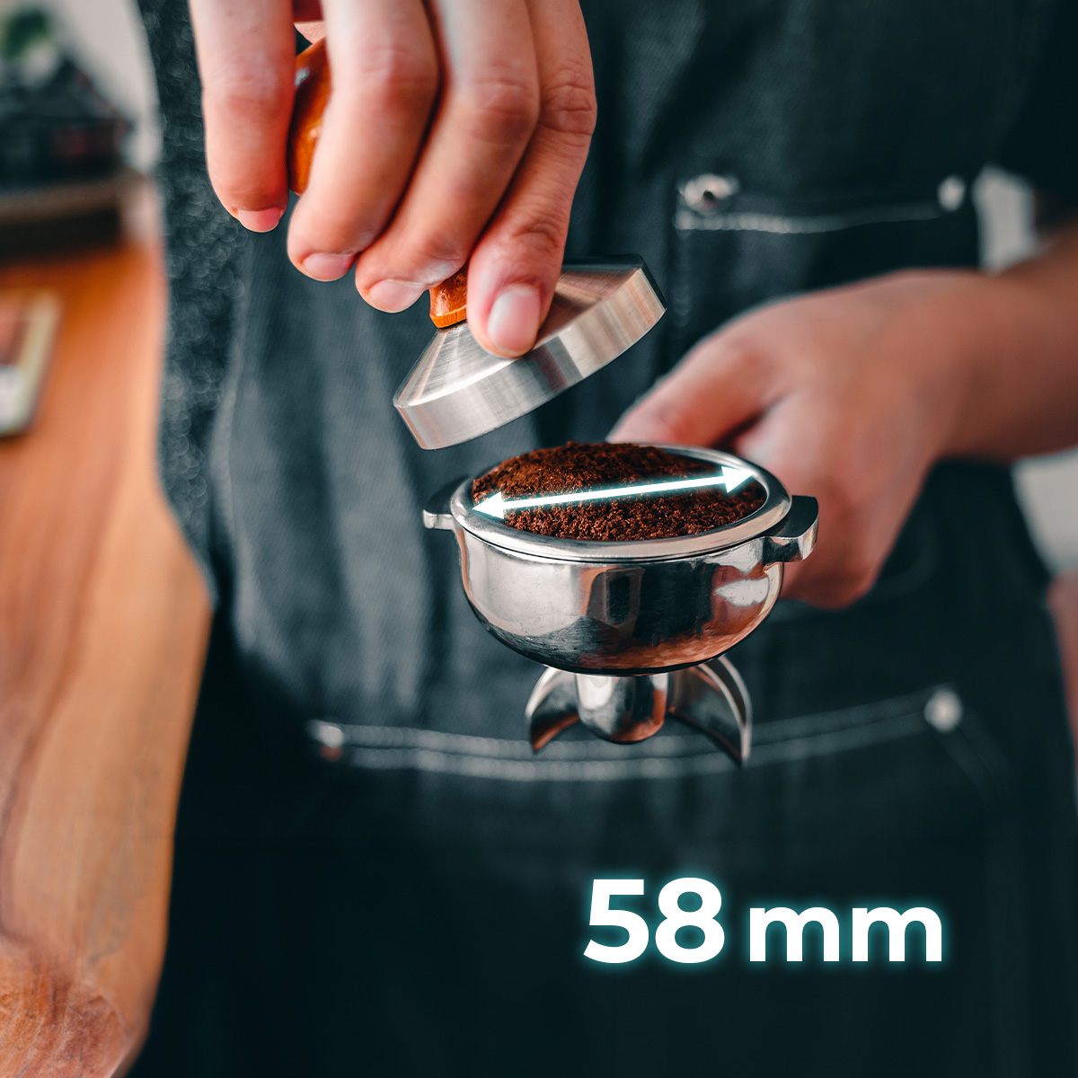 Qualcuno che pressa il caffè in un portafiltro da 58 mm.