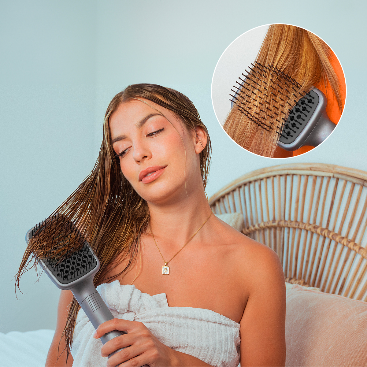 Una donna con asciugamano asciuga i capelli bagnati con una spazzola lisciante; dettaglio in alto.