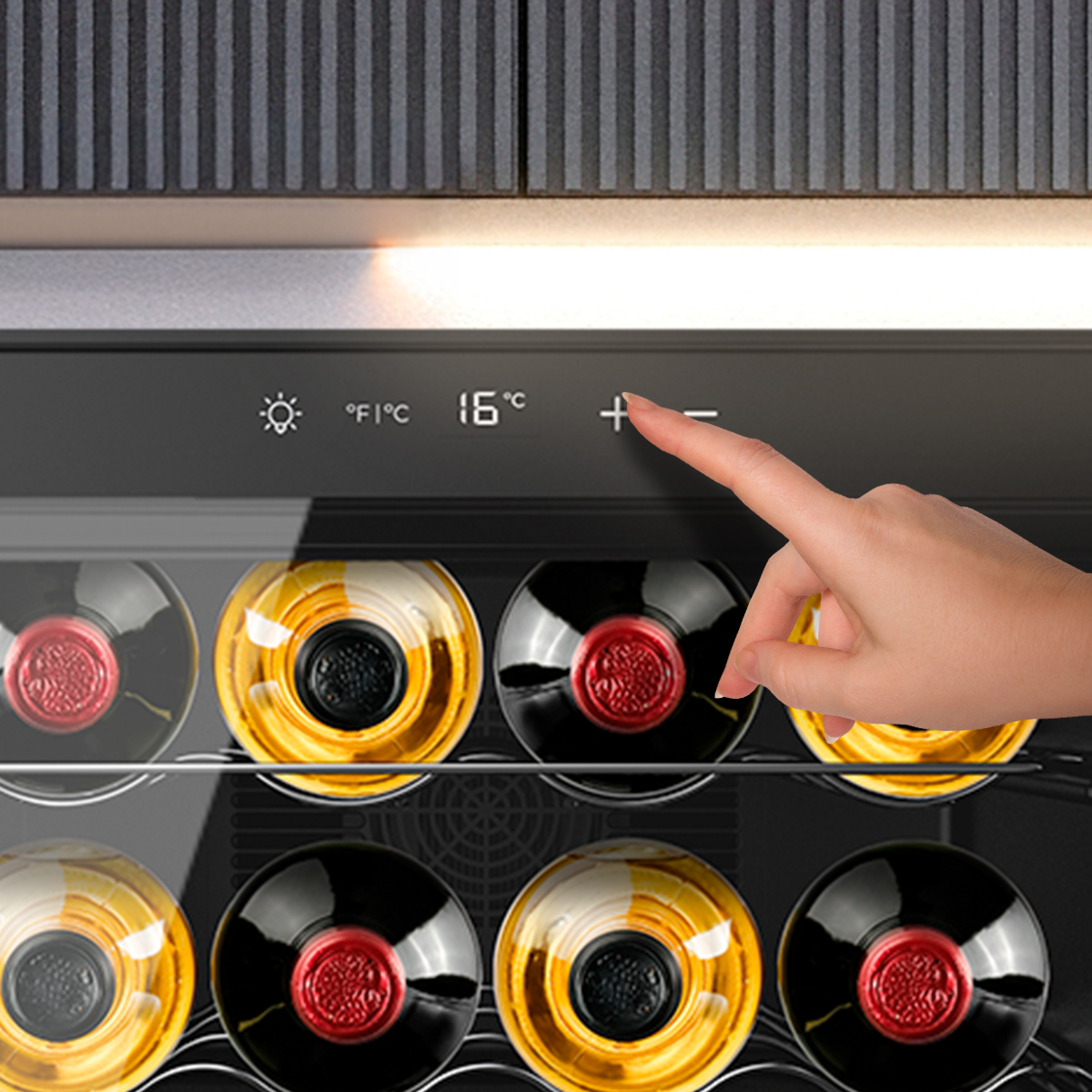 Mano che tocca il simbolo più sul pannello di controllo touch di una cantinetta per vini piena di bottiglie.