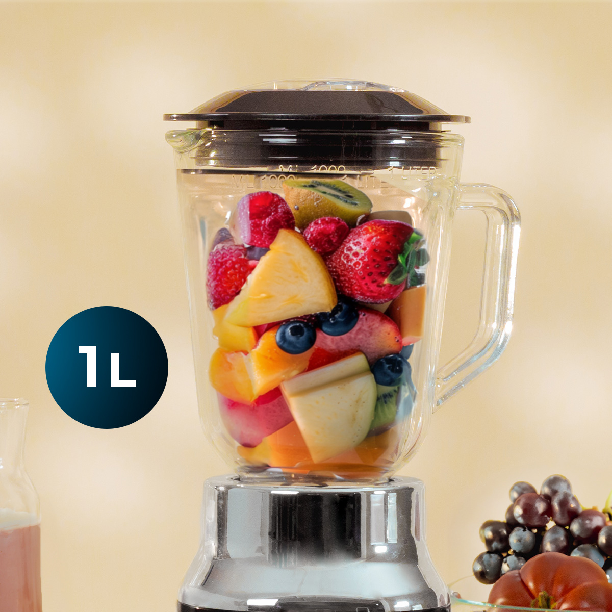 Ein gläserner Mixer mit gemischtem Obst wie Erdbeeren, Kiwi und Ananas und einem 1L-Etikett links.