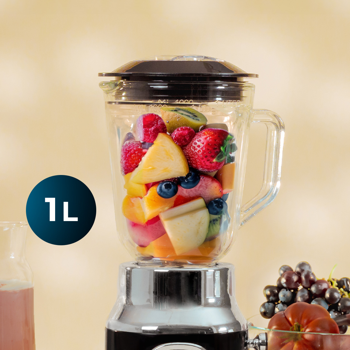 Una licuadora llena de frutas frescas como fresas y piña, junto a uvas y un icono de 1L.