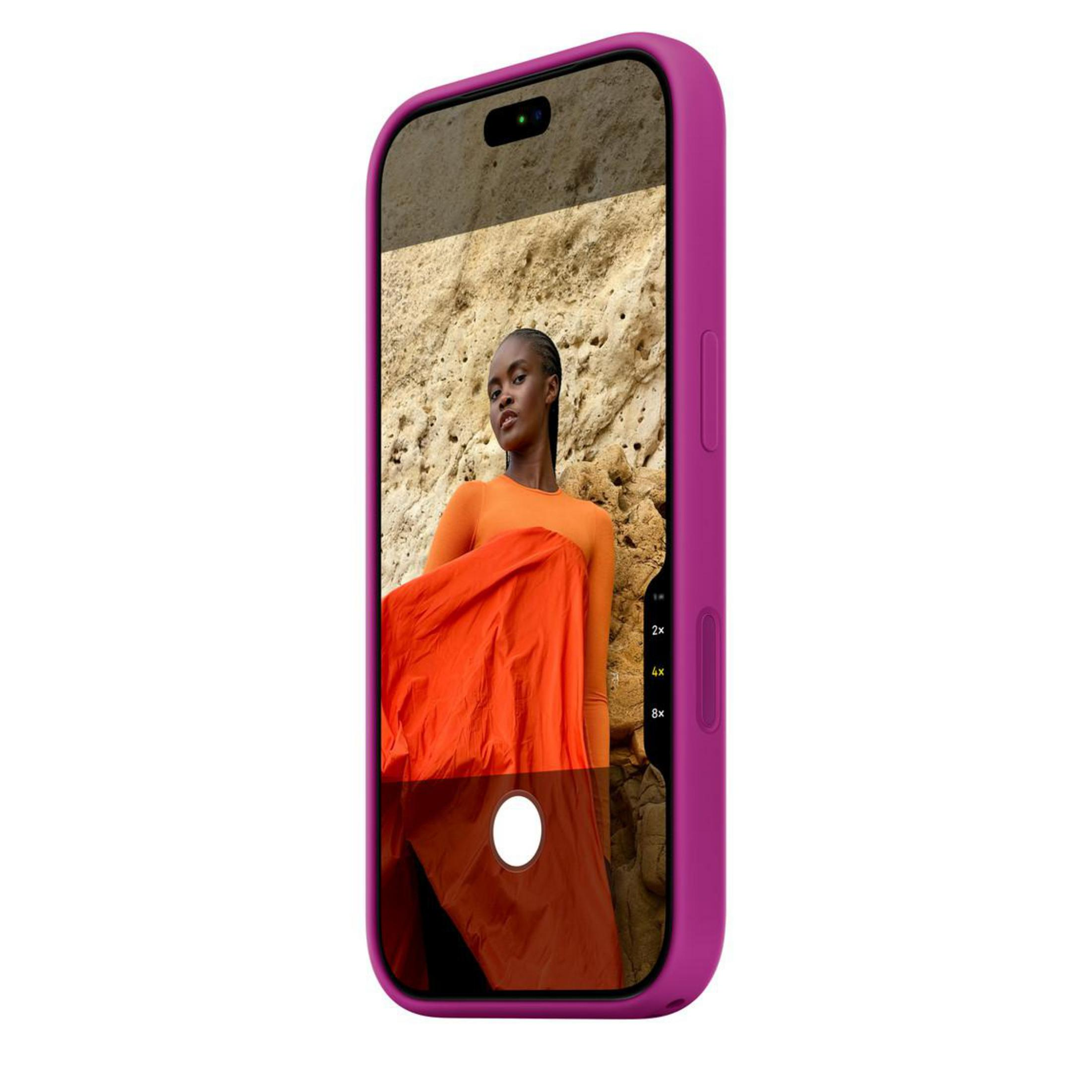 Smartphone rose affichant une femme en orange devant une falaise rocheuse.