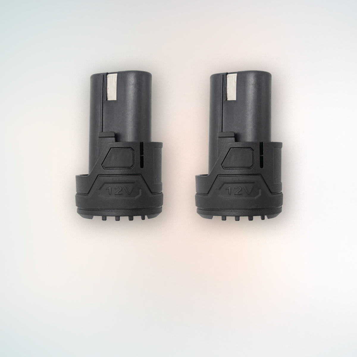 Dos baterías negras para herramientas de 12V están de pie una al lado de la otra sobre un fondo claro.