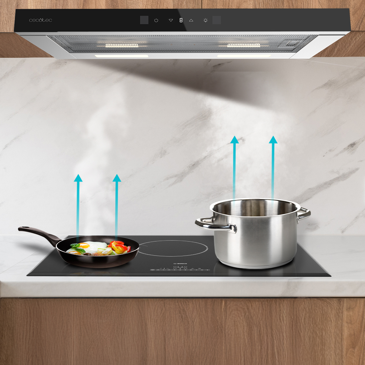 Campana extractora sobre una placa de inducción con una sartén, una olla y vapor ascendente.