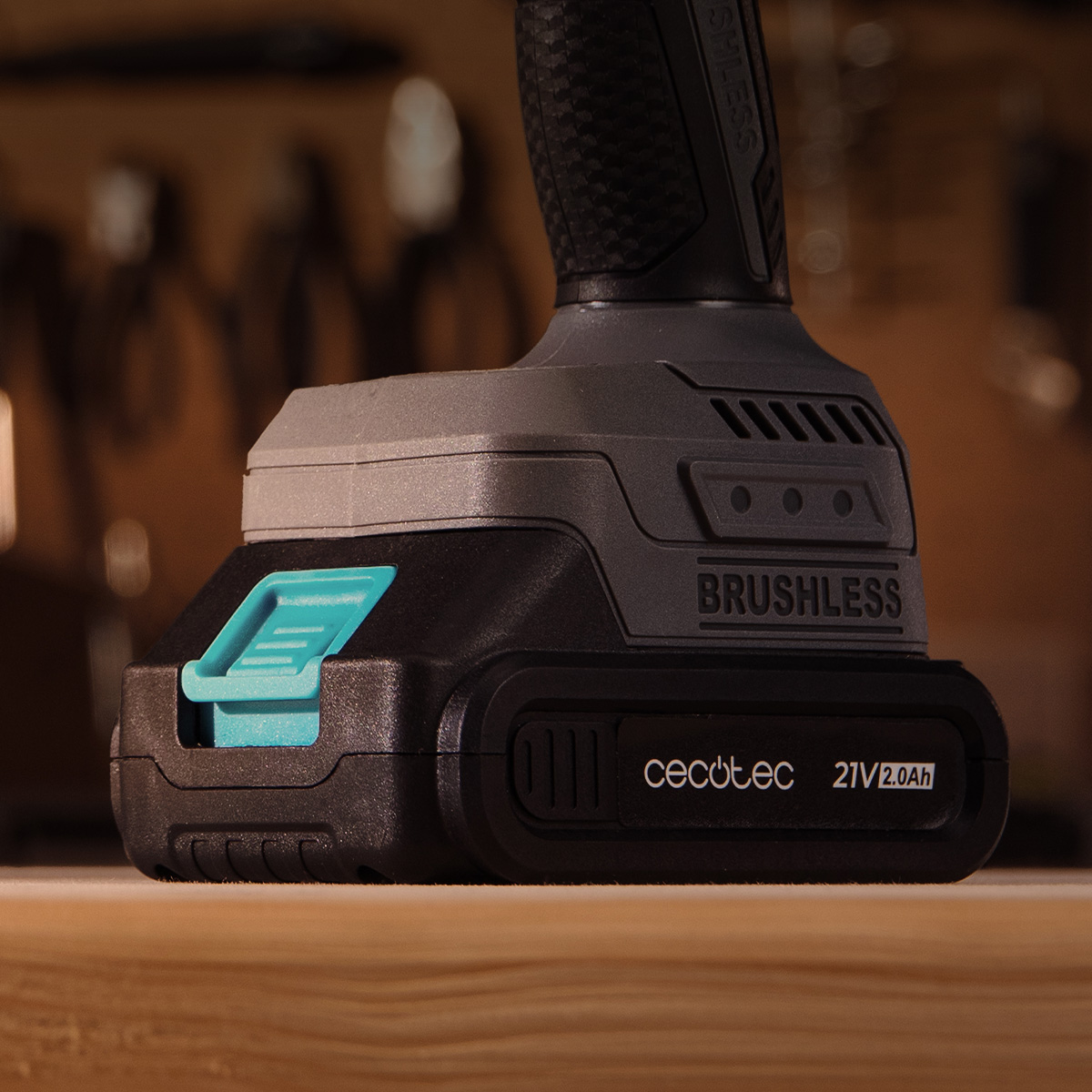 Un taladro inalámbrico Cecotec 21V 2.0Ah sobre una superficie de madera con fondo de herramientas.